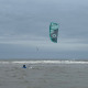 Vrouw bodydragt door de zee tijdens de les kitesurfen bij Surfschool Castricum.
