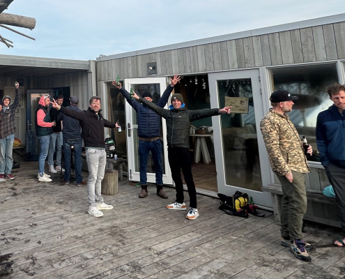 Leden van SAS staan gezellig te praten. Plezier van kitesurfen straalt er vanaf.