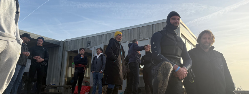 Leden bij Sports at Sea kijken naar kitesurfers. Winter warm blijven.