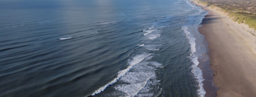 Luchtfoto van golven en duinen in Castricum.