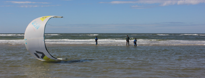 Vrouw herstart kite uit het water tijdens de les kitesurfen bij Surfschool Castricum. Kite herstarten.