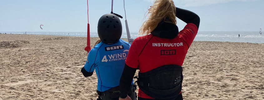 Anne houdt student vast tijdens de les kitesurfen bij Surfschool Castricum. Kitesurf kite besturen.
