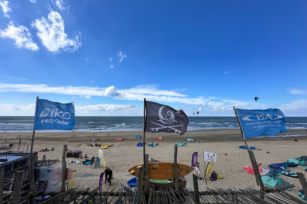 Een iko vlag, een jolly roger en een ISA vlag bij iko-gecertificeerde school surfschool Castricum.
