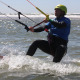 Man probeert op te staan met waterstart tijdens de les kitesurfen bij Surfschool Castricum. Bar aangetrokken en spanning op de lijnen.